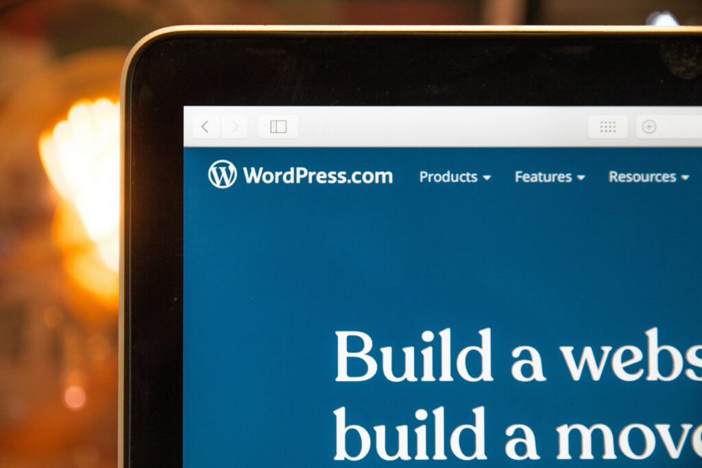 Close-up of a laptop screen showing the WordPress.com homepage with the heading Build a website, build a movement